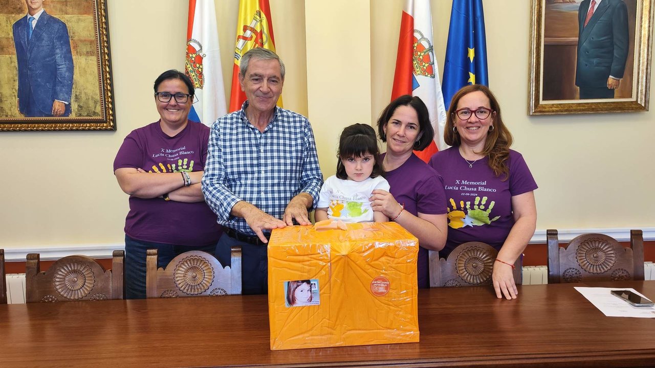 El alcalde y las organizadoras de la marcha con la urna solidaria